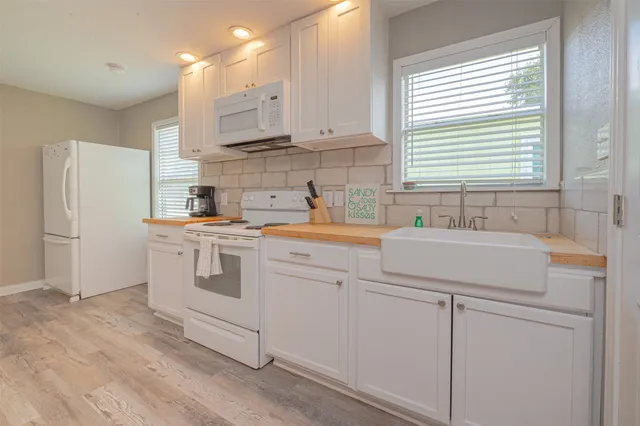 a kitchen with white cabinets and white appliances