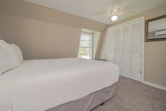 a large bed sitting in a bedroom next to a window