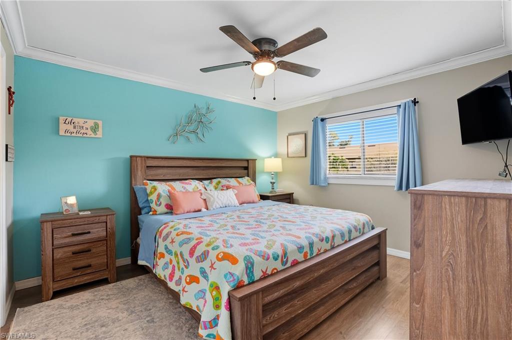 4790 South Cleveland Avenue, Unit 907 Fort Myers, FL 33907 - Photo 12 of 24 Primary bedroom featuring crown molding, laminate floors, and ceiling fan