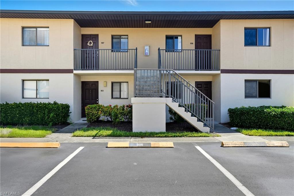 4790 South Cleveland Avenue, Unit 907 Fort Myers, FL 33907 - Photo 2 of 24 View of condo building featuring stairway and uncovered parking
