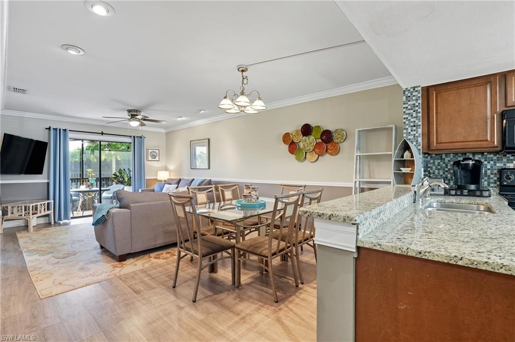 4790 South Cleveland Avenue, Unit 907 Fort Myers, FL 33907 - Photo 8 of 24 Dining area with ornamental molding, laminate floors, and chandelier