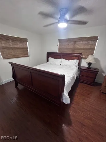a spacious bedroom with a bed and wooden floor