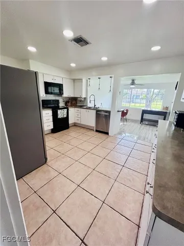 a kitchen with stainless steel appliances kitchen island granite countertop a refrigerator and a stove top oven a sink with granite countertops