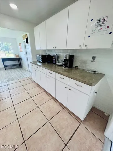 a kitchen with stainless steel appliances granite countertop a sink a stove a microwave and white cabinets