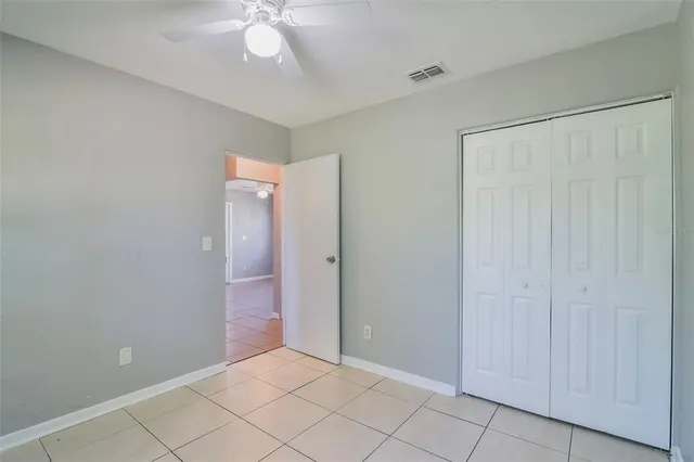 an empty room with fan and entrance