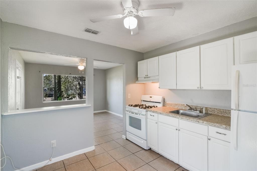 1220 Morin Street, Unit A Eustis, FL 32726 - Photo 7 of 20 a kitchen with granite countertop a stove a cabinets and a window