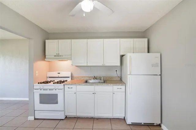 a kitchen with white cabinets and white appliances