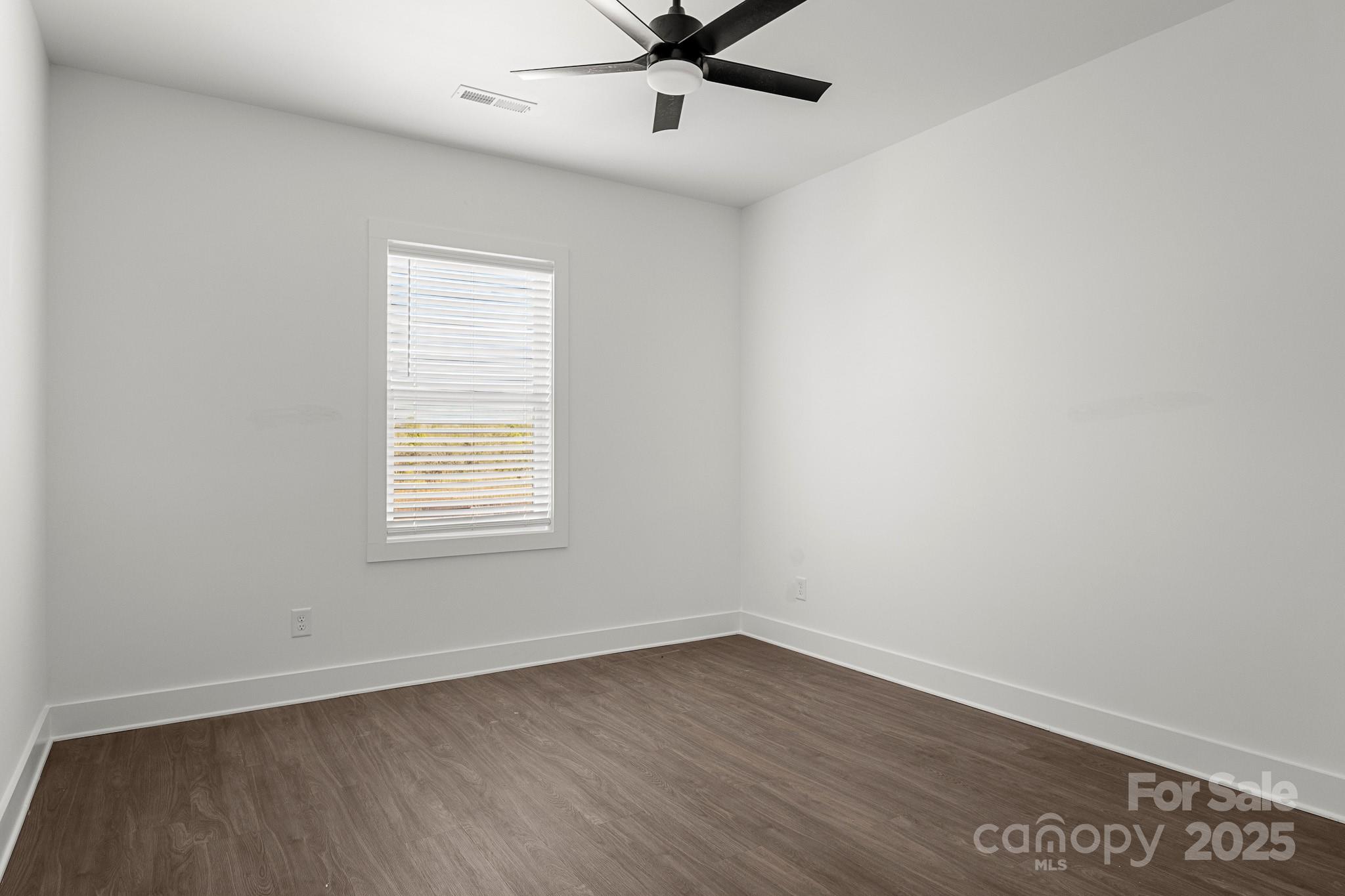 3303 Old Pageland Monroe Road Monroe, NC 28112 - Photo 24 of 37 an empty room with wooden floor fan and windows