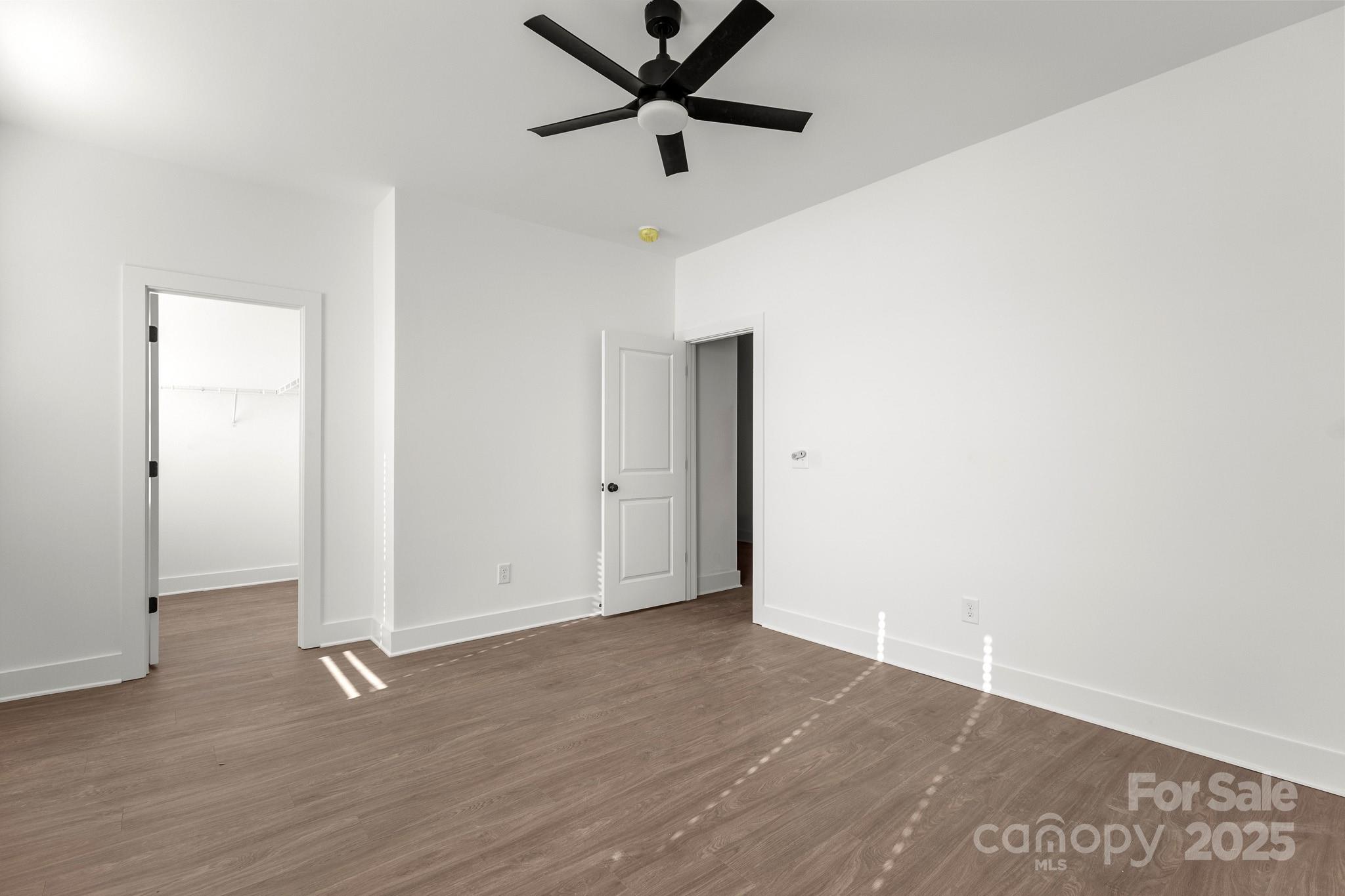 3303 Old Pageland Monroe Road Monroe, NC 28112 - Photo 29 of 37 an empty room with wooden floor and a ceiling fan