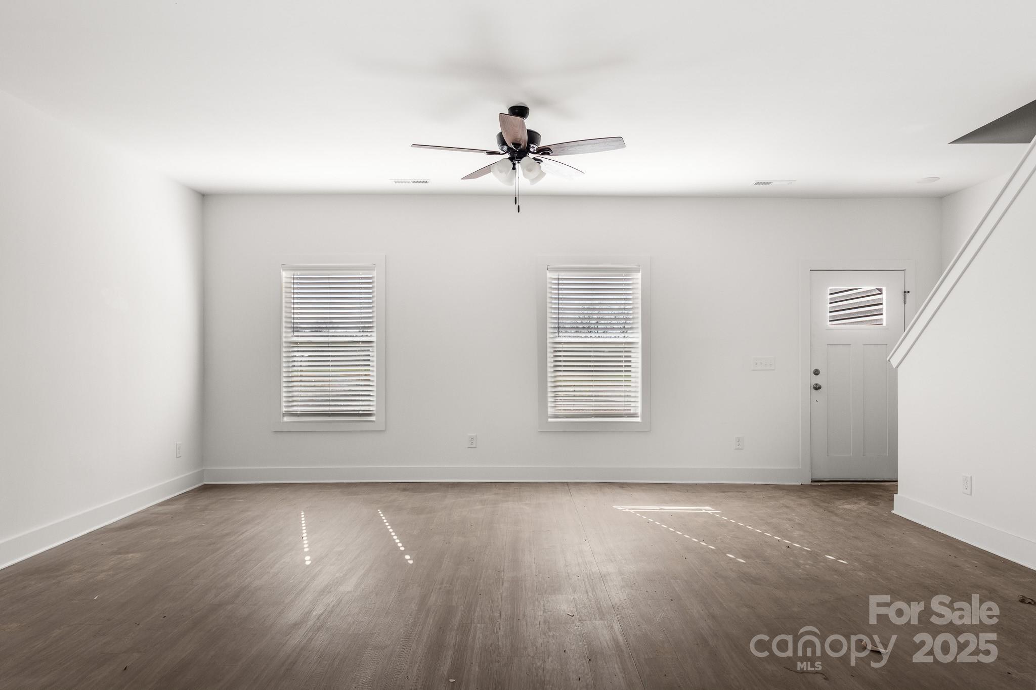 3303 Old Pageland Monroe Road Monroe, NC 28112 - Photo 3 of 37 an empty room with wooden floor fan and windows