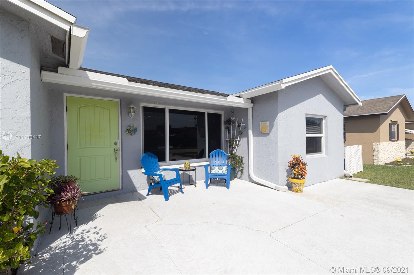 22565 Southwest 56th Avenue Boca Raton, FL 33433 - Photo 12 of 35 a front view of a house with outdoor seating and a potted plant