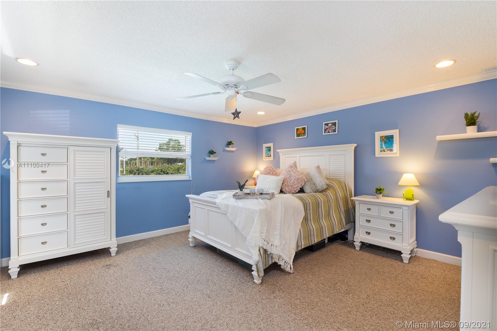 22565 Southwest 56th Avenue Boca Raton, FL 33433 - Photo 25 of 35 a spacious bedroom with a bed and a cabinets