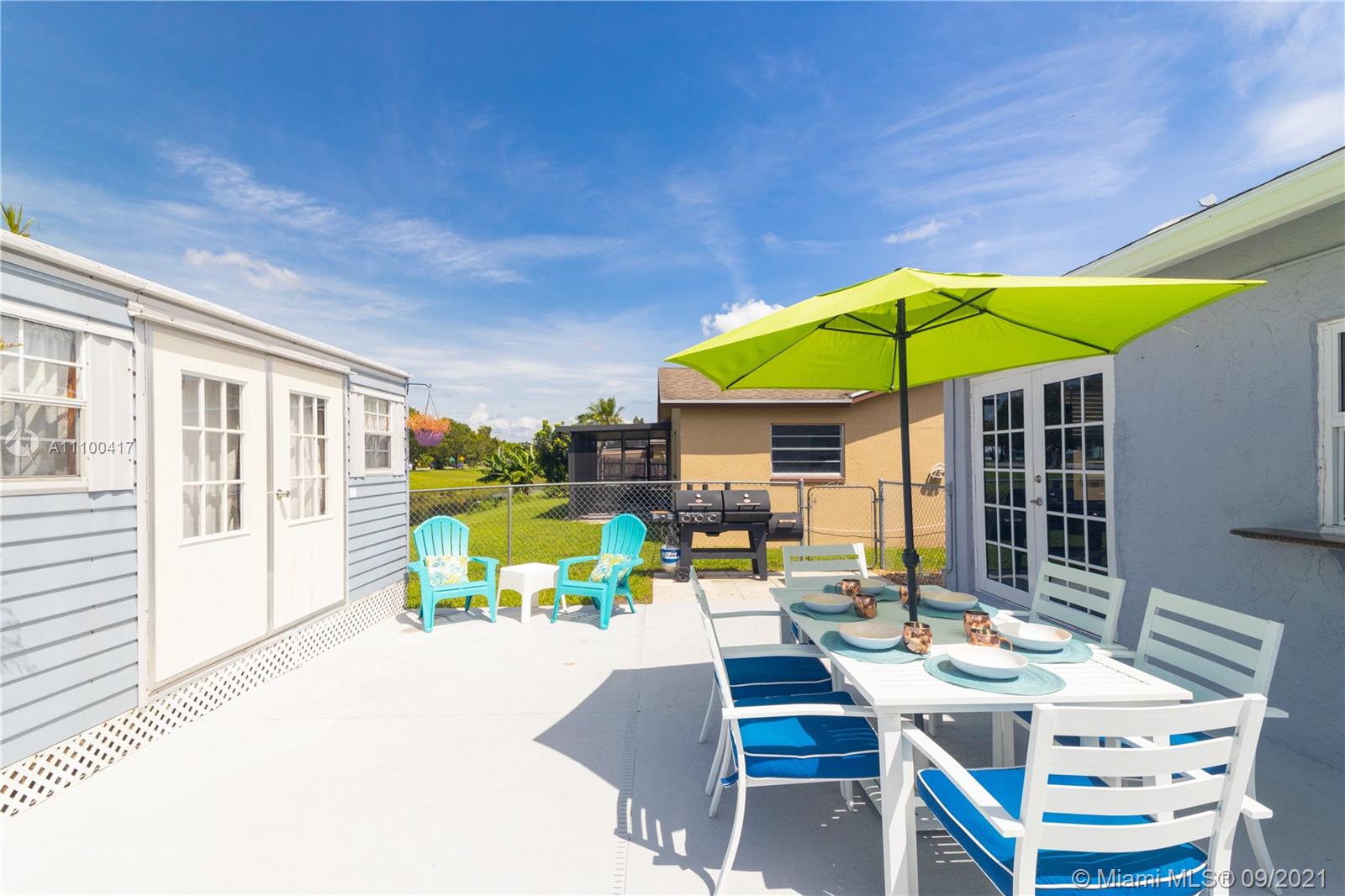 22565 Southwest 56th Avenue Boca Raton, FL 33433 - Photo 33 of 35 a patio with a table and chairs under an umbrella