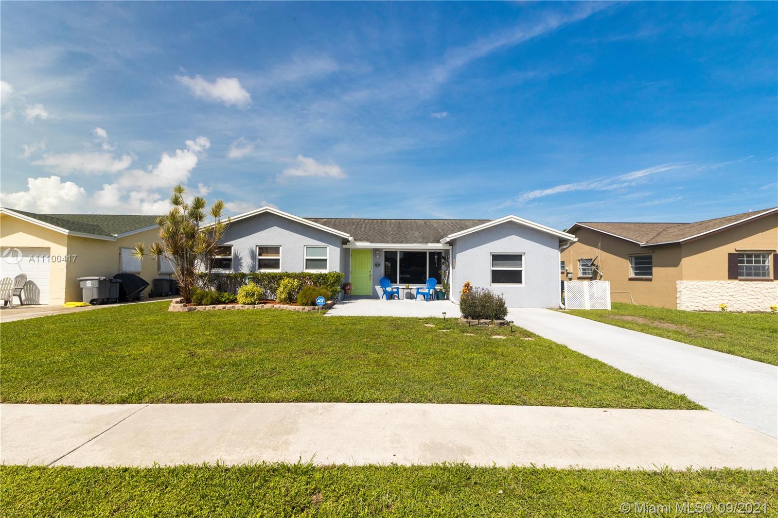 22565 Southwest 56th Avenue Boca Raton, FL 33433 - Photo 5 of 35 a front view of a house with a yard