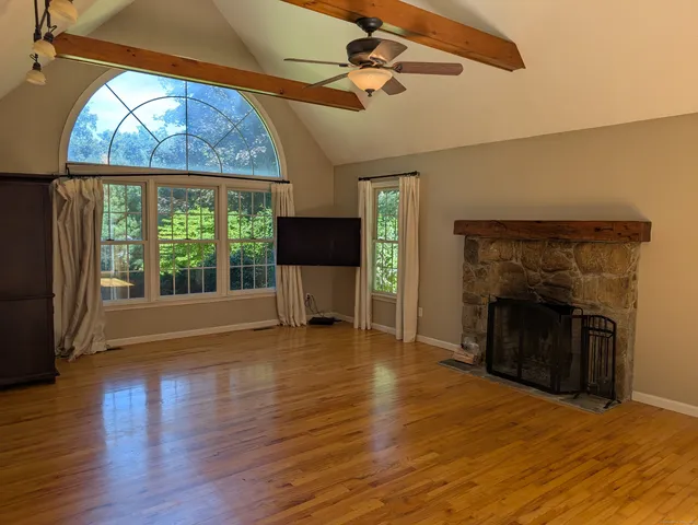 wooden floor fireplace and windows in an empty room