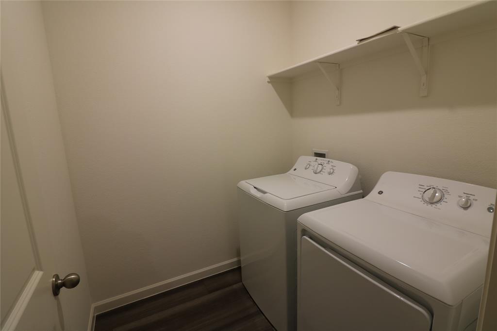 1301 Elliott Road Howe, TX 75459 - Photo 24 of 27 Dedicated laundry area with a white shelving unit, white walls, and wood-finish flooring
