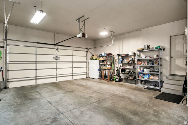 288 525 South Providence, UT 84332 - Photo 42 of 71 Spacious garage featuring a concrete floor, overhead fluorescent lighting, and an automatic garage door opener