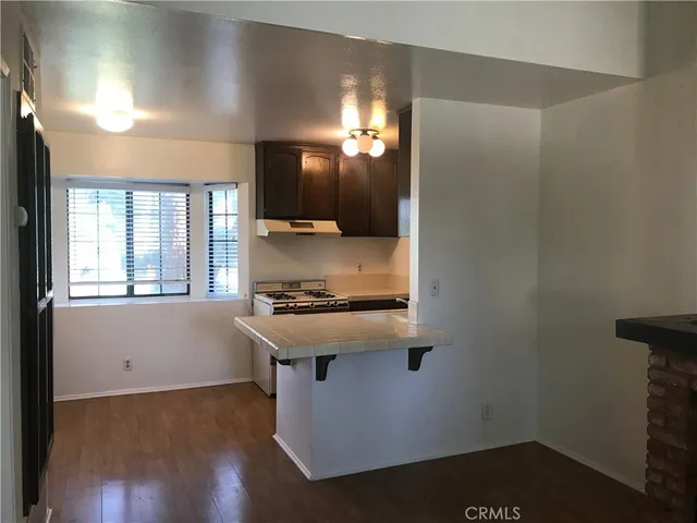 a kitchen with kitchen island a sink stove and wooden floor