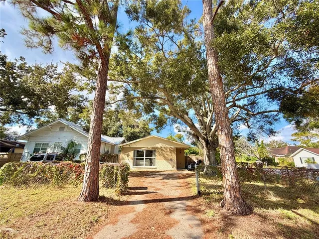 a white house that has a tree in front of it
