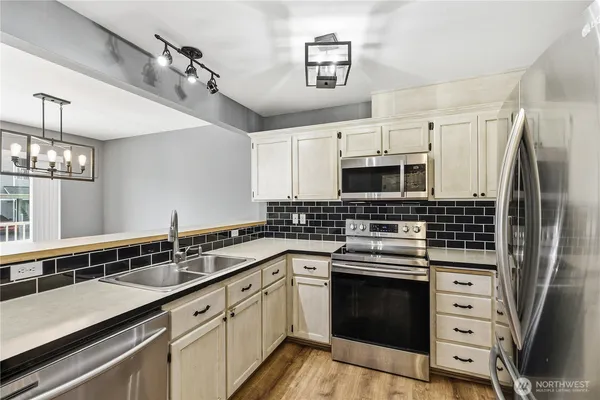 a kitchen with a sink stove and microwave