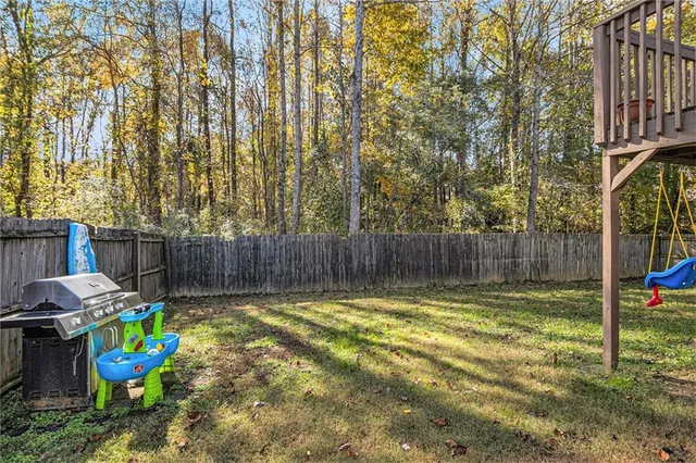 a view of a backyard with plants and wooden fence