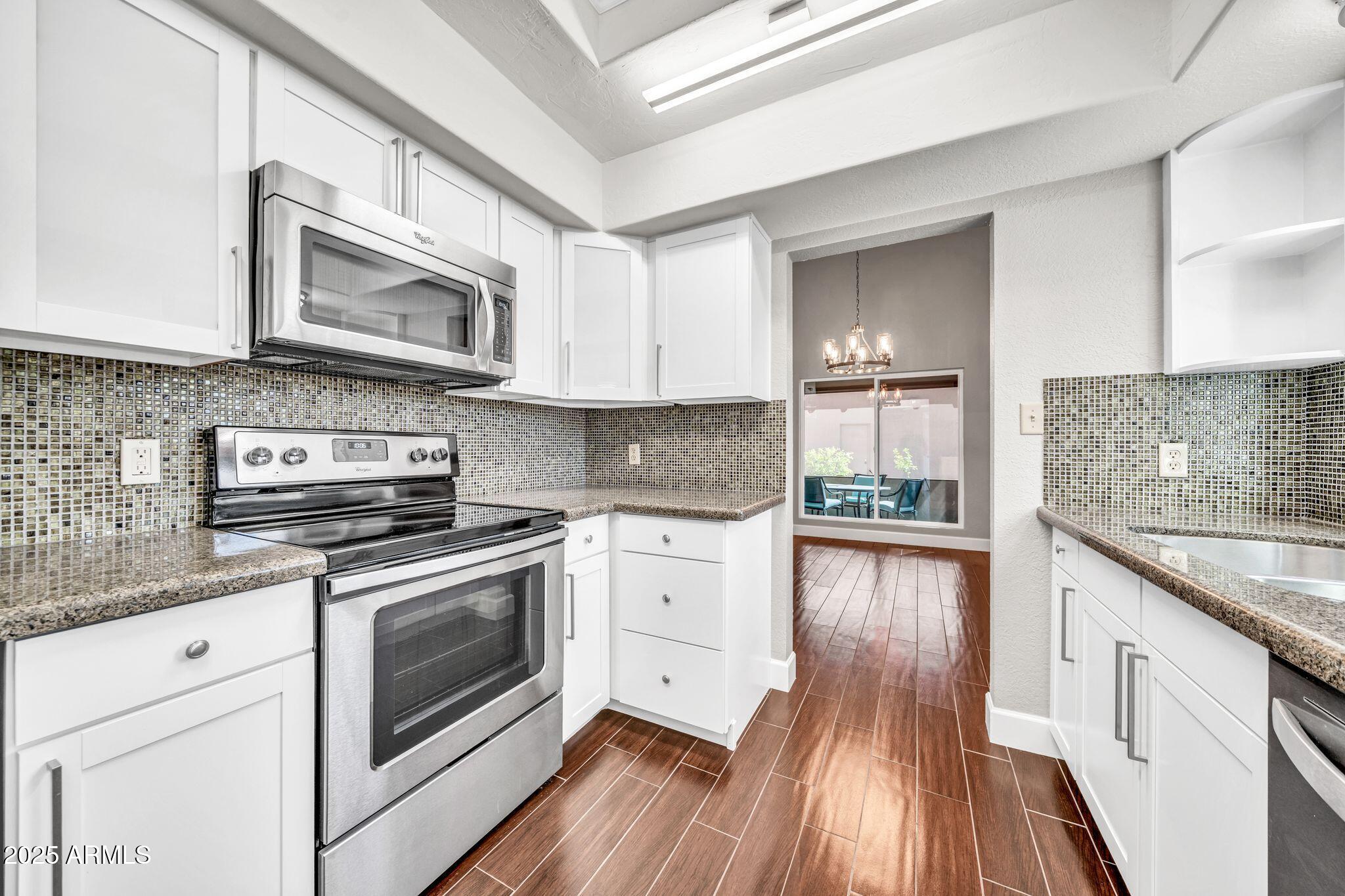 18548 East Parada Circle Rio Verde, AZ 85263 - Photo 4 of 35 a kitchen with stainless steel appliances granite countertop a stove and a sink
