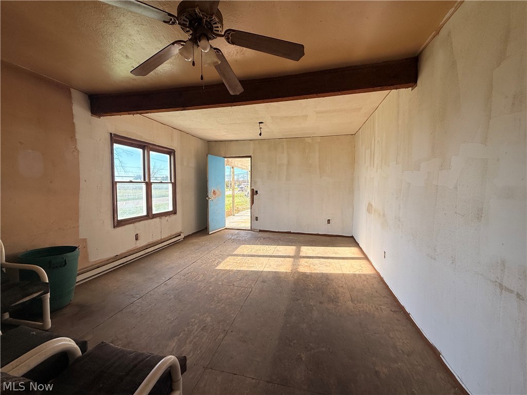 4772 Highway 45 Rome, OH 44085 - Photo 31 of 38 Spacious room with a ceiling fan, exposed wood beam, and baseboard heating