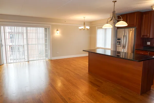 a view of a room with wooden floor and a chandelier