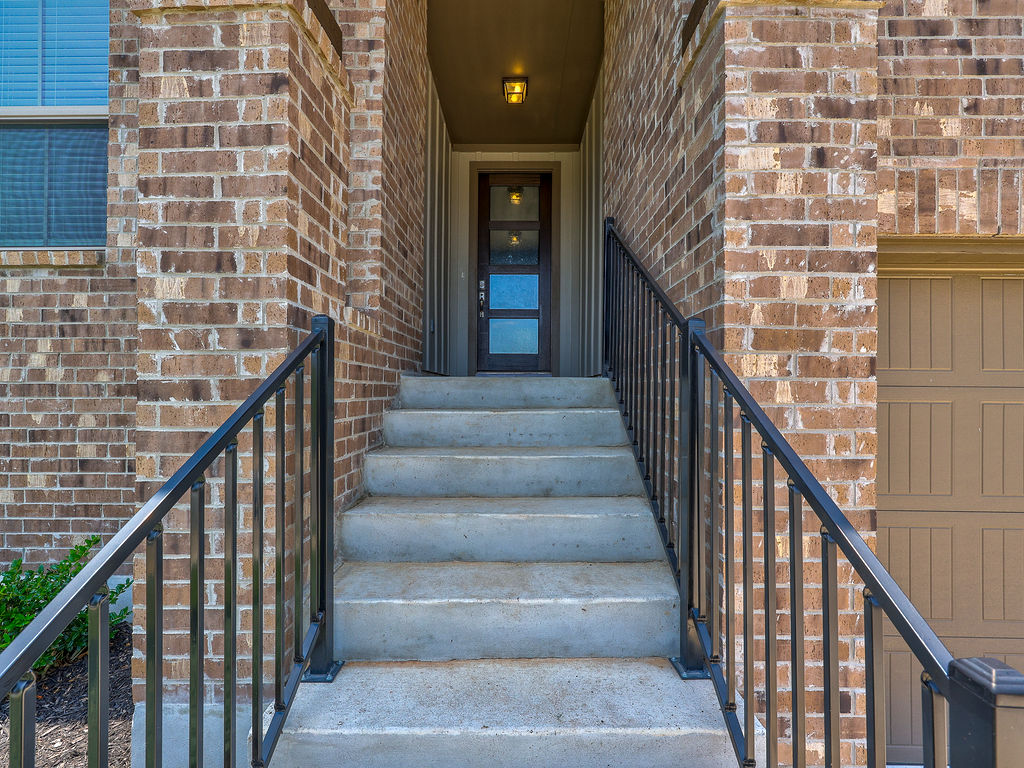 229 Heartleaf Road San Marcos, TX 78666 - Photo 3 of 40 A welcoming brick facade with steps leading to a modern entry door, promising comfortable living.