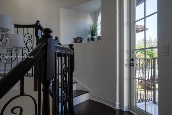 a view of a hallway with wooden floor and a bathroom