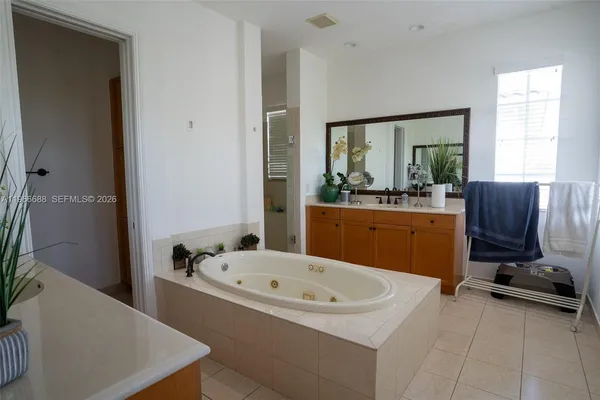 a bathroom with a tub sink and mirror