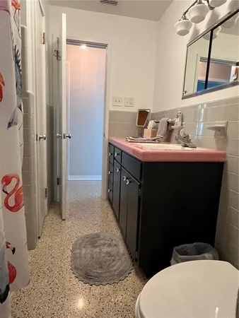 a bathroom with a granite countertop sink a toilet and mirror