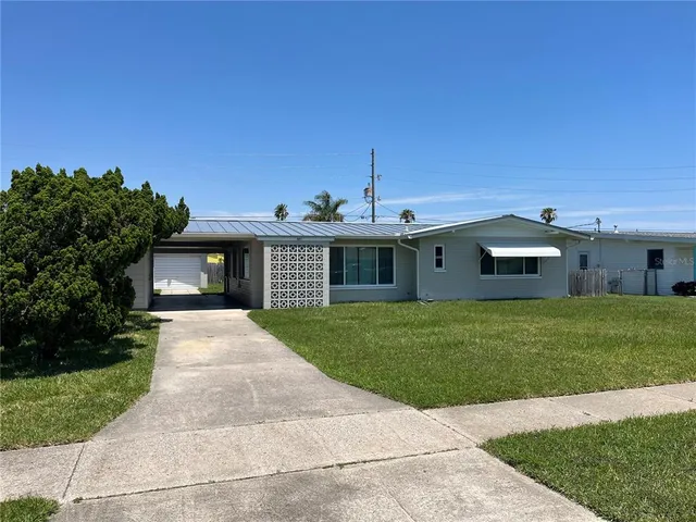 a front view of a house with a yard and trees