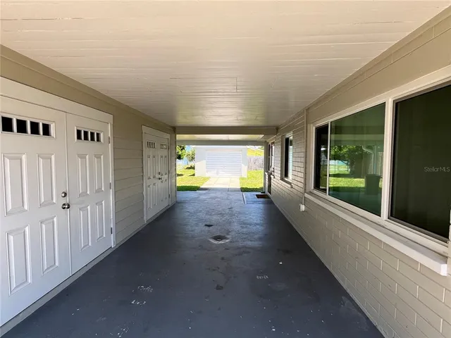 a view of a hallway with wooden floor and a yard