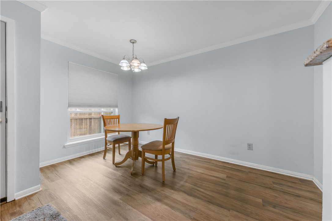 2807 Wildflower Drive, Unit 13 Bryan, TX 77802 - Photo 8 of 16 a dining room with wooden floor a chandelier a glass table and chairs