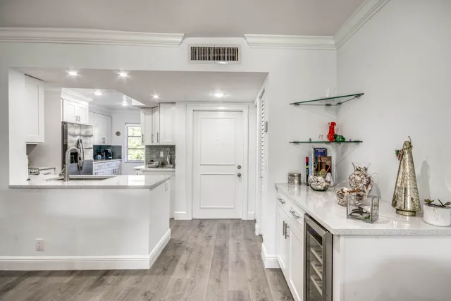 a kitchen with kitchen island white cabinets and refrigerator