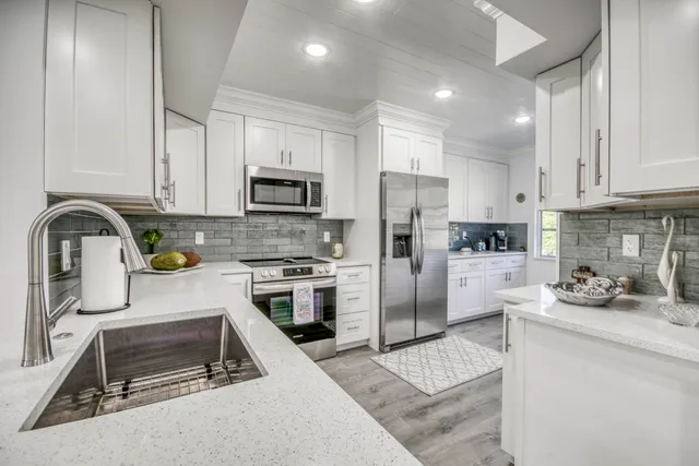 a kitchen with refrigerator a stove and a sink