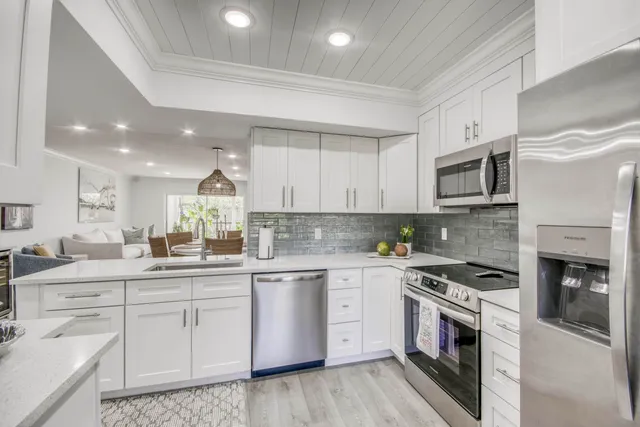 a kitchen with white cabinets stainless steel appliances and a counter space