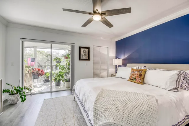 a bedroom with a balcony a bed and a chandelier