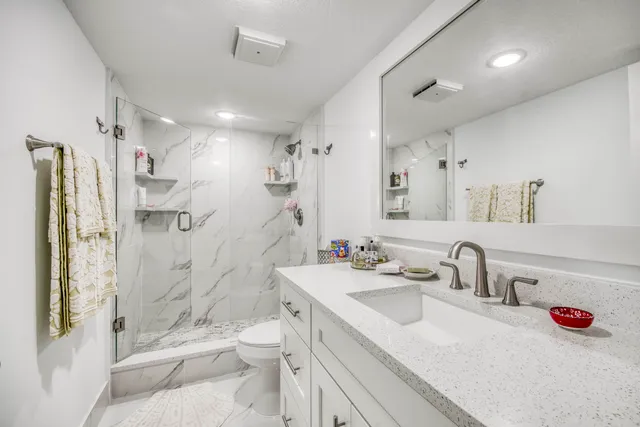 a bathroom with a sink toilet tub and shower