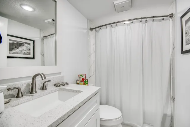 a bathroom with a sink toilet and shower