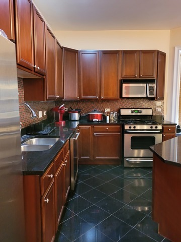 4546 South Indiana Avenue, Unit 2N Chicago, IL 60653 - Photo 6 of 16 a kitchen with a sink stove top oven and cabinets