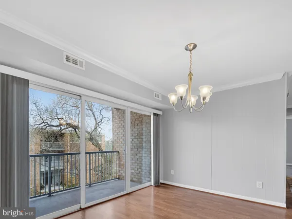 a view of a livingroom with wooden floor and a large window