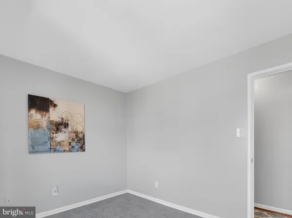 an empty room with a painting on the wall