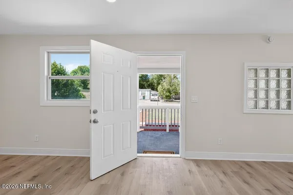 a kitchen with stainless steel appliances granite countertop a refrigerator a sink a stove and white cabinets with wooden floor