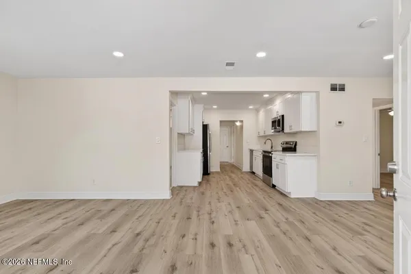 an empty room with wooden floor and a ceiling fan