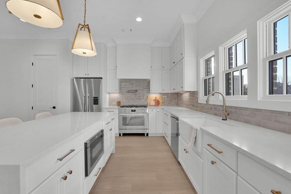 332 Sugarview Road, Unit 16 Sugar Hill, GA 30518 - Photo 3 of 31 a large white kitchen with stainless steel appliances kitchen island granite countertop a sink and cabinets