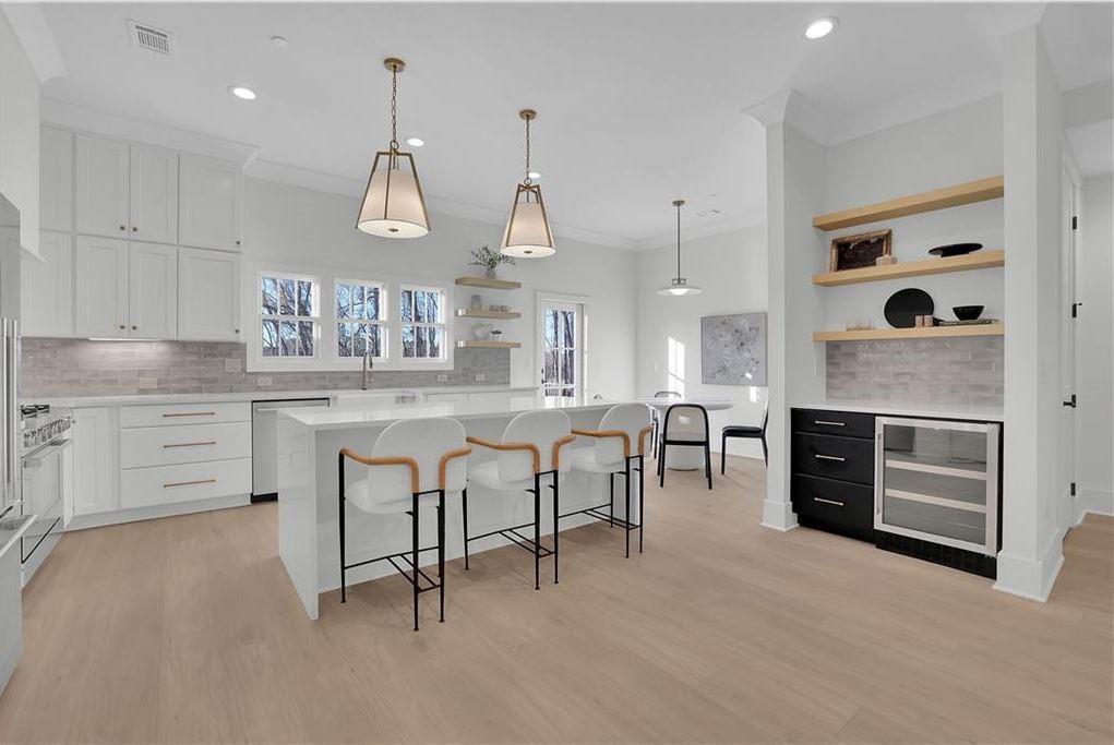 332 Sugarview Road, Unit 16 Sugar Hill, GA 30518 - Photo 5 of 31 a kitchen with stainless steel appliances kitchen island granite countertop a stove a sink a dining table and chairs with wooden floor