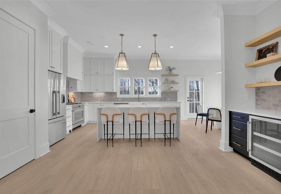 332 Sugarview Road, Unit 16 Sugar Hill, GA 30518 - Photo 6 of 31 a kitchen with stainless steel appliances kitchen island granite countertop a table chairs sink and cabinets