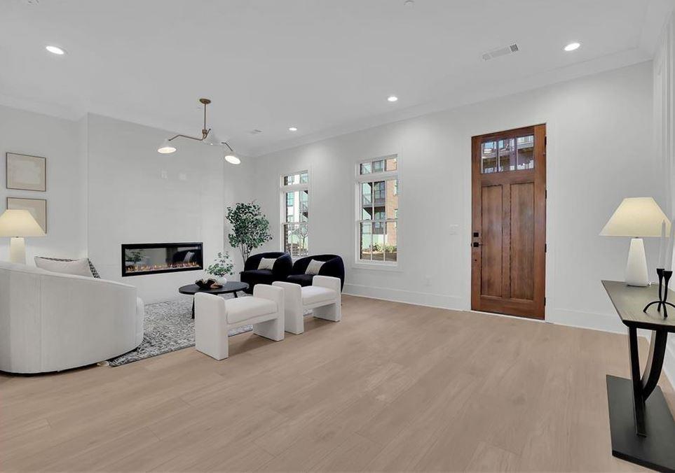 332 Sugarview Road, Unit 16 Sugar Hill, GA 30518 - Photo 9 of 31 a living room with furniture a chandelier and a flat screen tv